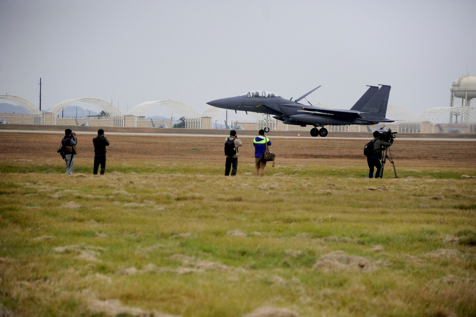 Media gathers by the flight line to document a Republic of Korea air force F-15 Slam Eagle landing during the Max Thunder exercise at Kunsan Air Base, Republic of Korea, Nov. 6, 2013. Hosting members of the international media community enhances a global understanding and awareness of exercises like Max Thunder that demonstrate joint service capabilities. (U.S. Air Force photo by Staff Sgt. Jessica Haas/Released)