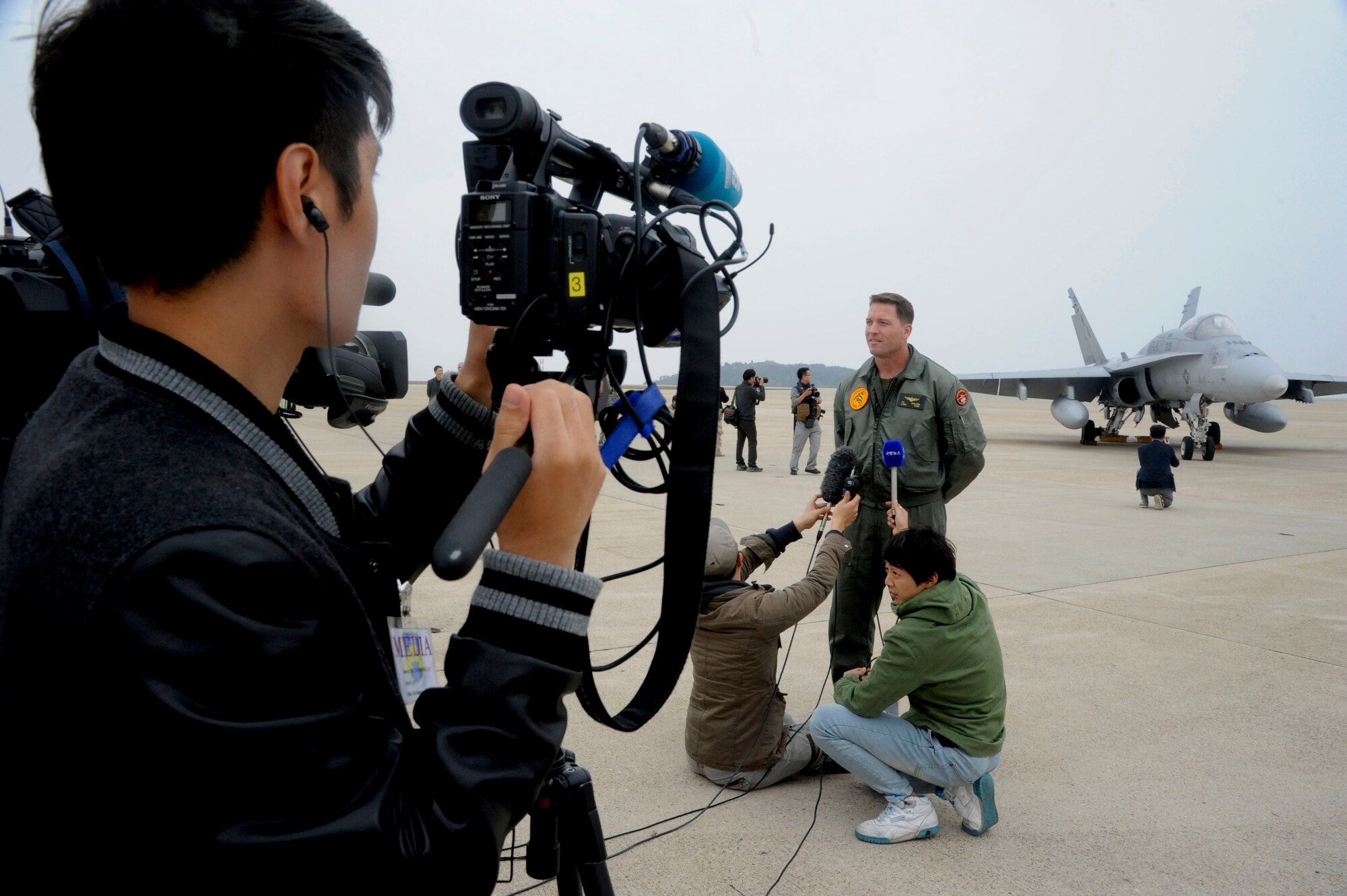 Media gathers to interview Lt. Col. Patrick Houlahan, VMFA-112 pilot, during the Max Thunder exercise at Kunsan Air Base, Republic of Korea, Nov. 6, 2013. Hosting members of the international media community enhances a global understanding and awareness of exercises like Max Thunder that demonstrate joint service capabilities. (U.S. Air Force photo by Staff Sgt. Jessica Haas/Released)