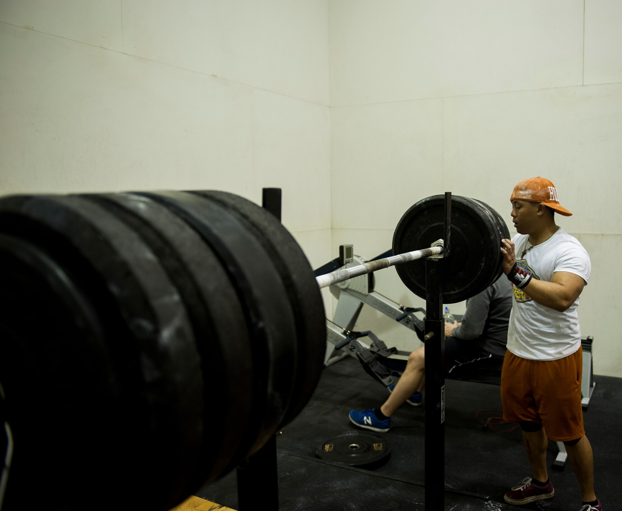 Airman 1st Class Benny Le, 8th Security Forces Squadron response force leader, adds more weight in between squats at Kunsan Air Base fitness center, Republic of Korea. Le is a member of the Air Force Powerlifting Team and will represent the Air Force in a competition in March. (U.S. Air Force photo by Senior Airman Clayton Lenhardt/Released)