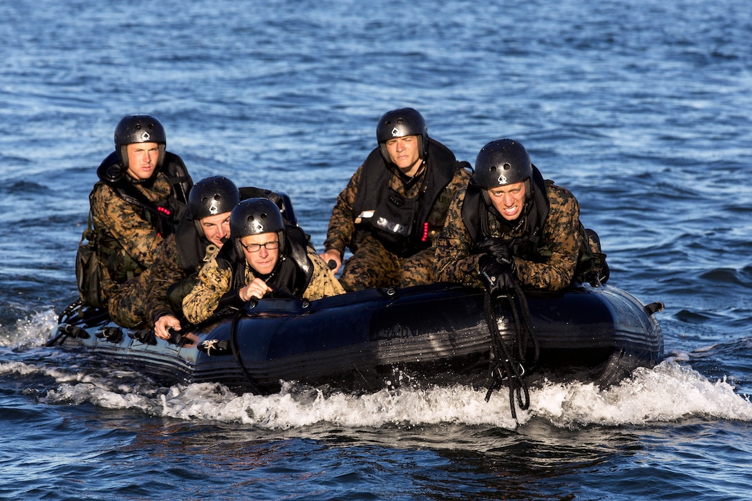 Marines and sailors ride their zodiac back toward the dock after ...