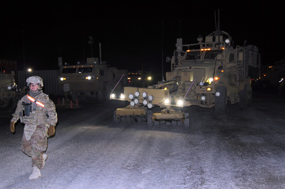 U.S. Army Spc. Evie Valk ground guides a vehicle through the motor pool on Kandahar Airfield before a tactical convoy mission to Forward Operating Base Tarin-Kwot, Afghanistan, Nov. 6, 2013. Valk is assigned to the 1113th Transportation Company, 152nd Combat Sustainment Support Battalion, 15th Sustainment Brigade.
