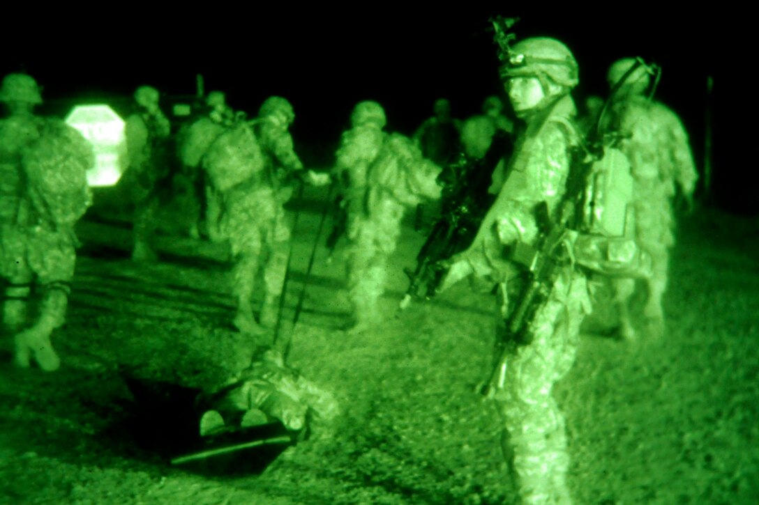 As seen through a night-vision device, paratroopers prepare a simulated casualty for medical evacuation during a night operation mission on Fort Bragg, N.C., Oct. 31, 2013. 