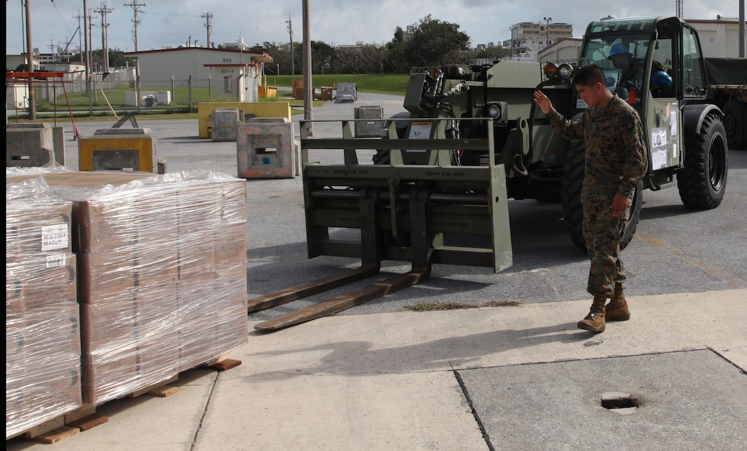 Pfc. Arturo Menchaca uses hand signals to direct Lance Cpl. Bryce E. Sanglay as he drives an extended boom forklift at Marine Corps Air Station Futenma, Okinawa, Japan, Nov. 10 during preparation for a humanitarian assistance and disaster relief mission to the Philippines. Approximately 90 U.S. Marines and Sailors from 3rd Marine Expeditionary Brigade departed on two KC-130J Hercules aircraft. At the request of the Government of the Philippines, Secretary of Defense Chuck Hagel has directed U.S. Pacific Command to support U.S. Government humanitarian assistance and disaster relief operations in the Philippines in the wake of Typhoon Haiyan. Sanglay is a logistics and embarkation specialist with Combat Logistics Battalion 4, Combat Logistics Regiment 3, 3rd Marine Logistics Group, III Marine Expeditionary Force and Menchaca is an engineer equipment operator with III MEF Headquarters Group. The aircraft are with Marine Aerial Refueler Transport Squadron 152, Marine Aircraft Group 36, 1st Marine Aircraft Wing, III MEF. MCAS Futenma is a mission ready air station capable of continuous aviation and base operating support for tenant organizations and follow-on U.S., Allied, and United Nations forces during combat or contingency operations in the Western Pacific Theater of operations, to include U.S. Pacific Command, Marine Corps Forces Pacific and Marine Corps Installations Pacific.