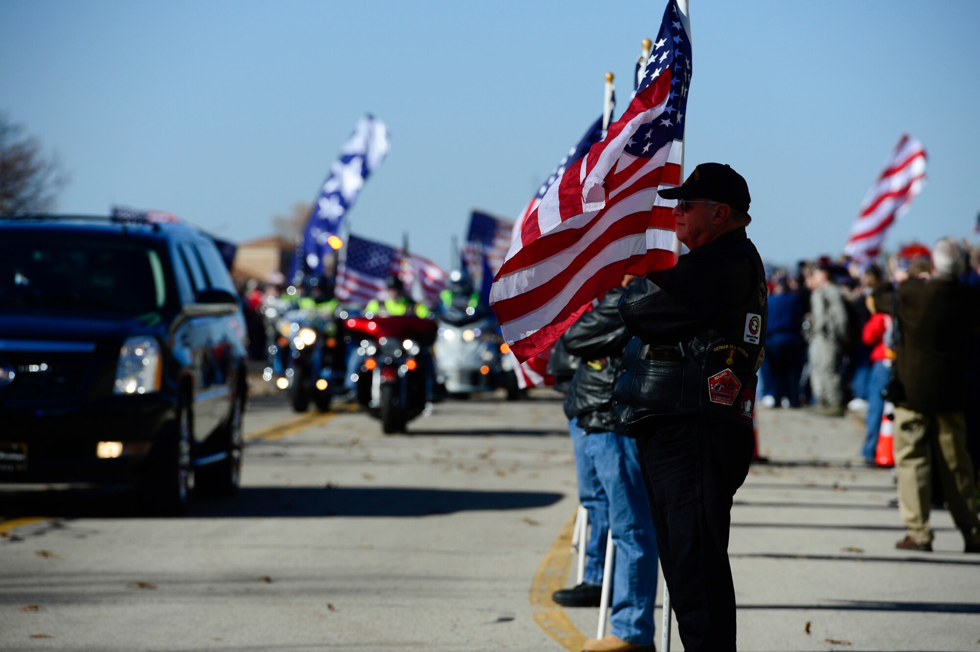 Veterans and the public line the streets of the National Museum of the U.S. Air Force with American flags and signs of support Nov. 09, 2013, during the Doolittle Toyko Raiders Memorial tribute in Dayton, Ohio. The tribute was held in honor of the last toast of the remaining Doolittle raiders. (U.S. Air Force photo/Desiree N. Palacios)