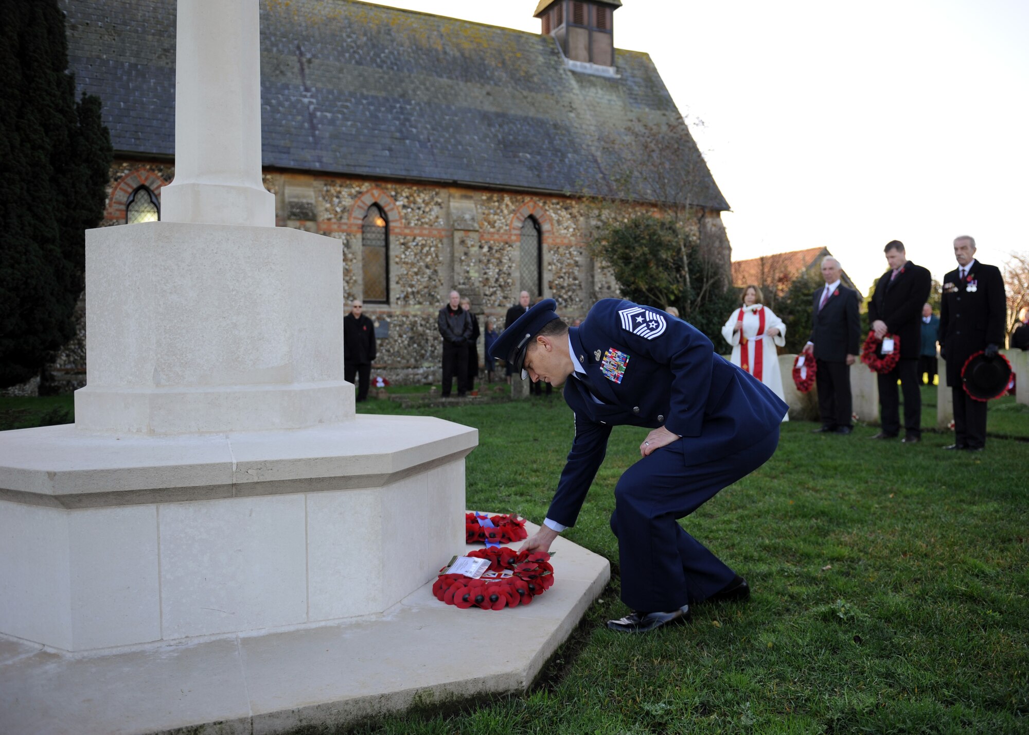 U.S. Air Force Chief Master Sgt. Tracy Jones, 100th Air Refueling Wing command chief, lays a wreath at the base of the War Graves Memorial during a Remembrance Day wreath-laying ceremony Nov. 10, 2013, in Beck Row in Suffolk, England. Remembrance Day is held in November every year as a way to pay respect to military members who lost their lives. The day was originally named Armistice Day after World War I, which ended at the 11th hour on the 11th day of the 11th month in 1918. (U.S. Air Force photo by Airman 1st Class Preston Webb/Released)