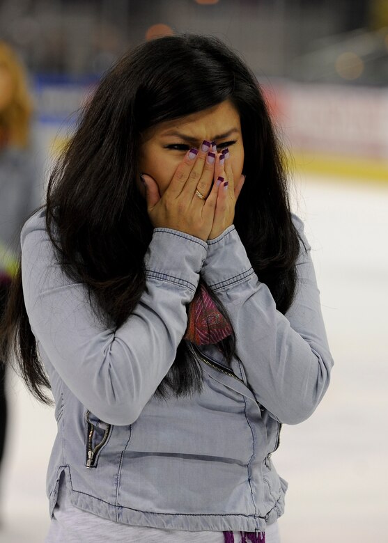 Eunah Hicks holds back tears as her husband, Staff Sgt. Dwight Hicks, 479th Flying Training Group aviation resource manager, revealed himself as the goalie for the hockey game half time show at Pensacola Bay Center in Pensacola, Fla., Nov. 9, 2013. Hicks surprised his family upon return from his deployment to Bagram Air Field, Afghanistan. (U.S. Air Force Photo/Airman 1st Class Jeff Parkinson)