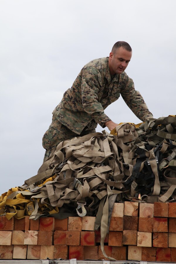 Chief Warrant Officer Allen T. Leiper uses cargo nets to secure palletized equipment Nov. 11 at Marine Corps Air Station Futenma, Okinawa, Japan. The equipment was later loaded onto a KC-130J Hercules aircraft to be used during humanitarian assistance and disaster relief operations in the Philippines in the aftermath of Super Typhoon Haiyan. The typhoon has impacted more than 4.2 million people across 36 provinces in the Philippines, according to the Philippine government’s national disaster risk reduction and management council. Leiper is an embarkation officer with III Marine Expeditionary Force Headquarters Group, III MEF. (U.S. Marine Corps photo by Lance Cpl. David N. Hersey/Released) 
