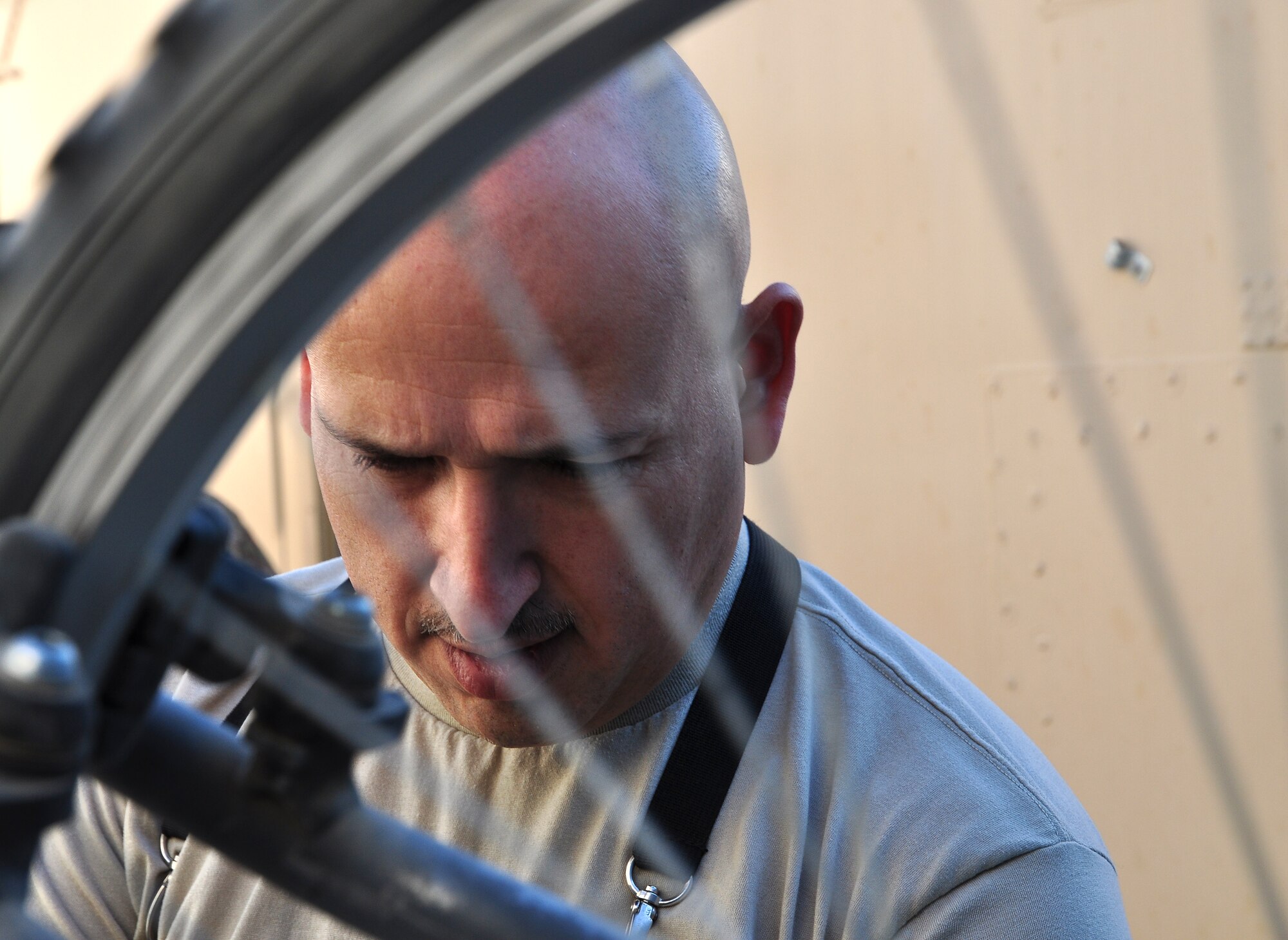 Tech. Sgt. Juan Sanchezduarte, 451st Expeditionary Logistics Readiness Squadron, works on a bicycle at Tan Box Bike Repair at Camp Losano, Kandahar Airfield, Afghanistan, Nov. 11, 2013. Sanchezduarte volunteers his time to give service members at KAF free bicycle repairs. (U.S. Air Force photo by Capt. Jason Smith)