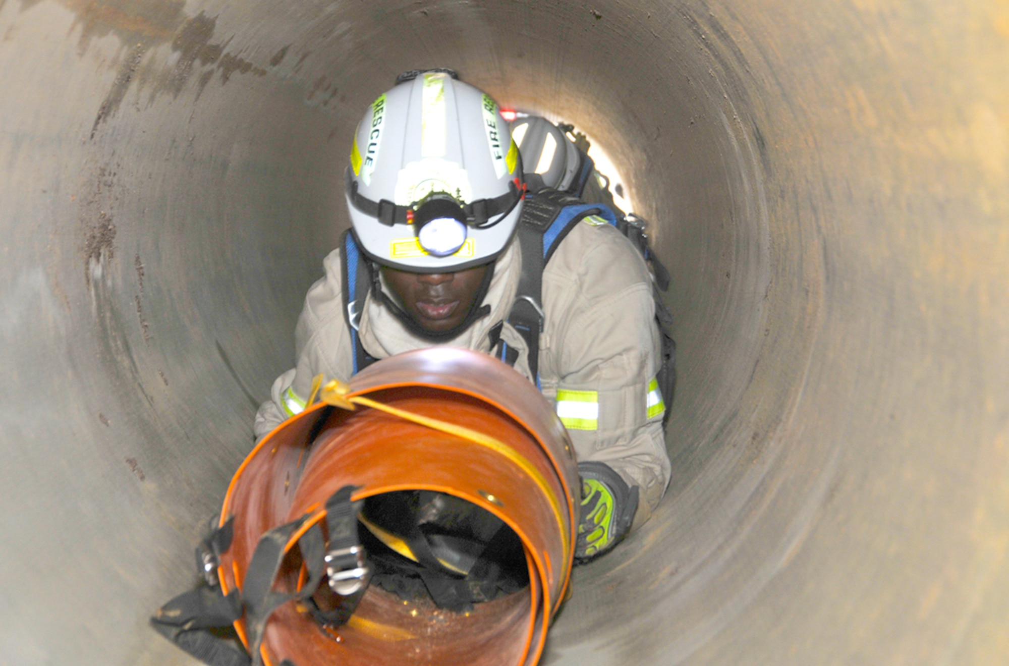Anthony Jimcoily, an AEDC fire fighter, crawls through a confined space to retrieve an injured worker as part of a recent mandatory annual rescue training exercise. (Photo by Rick Goodfriend)