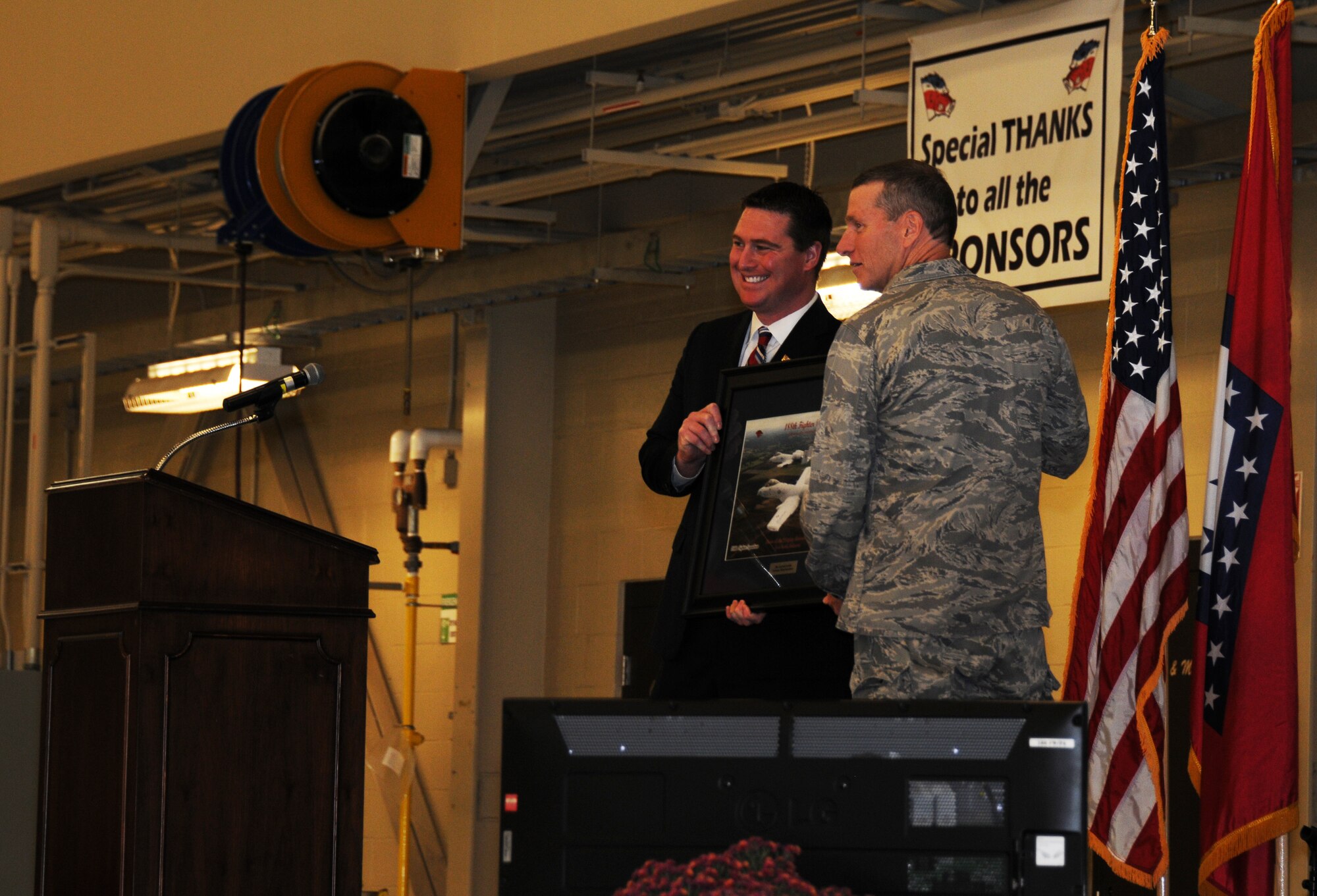 Col. Mark W. Anderson, 188th Fighter Wing commander, gives KFSM 5 News’ Garrett Lewis an Honorary Flying Razorback picture at the wing’s 60th anniversary celebration Nov. 2, 2013. Lewis, a meteorologist with the Fort Smith/Fayetteville CBS affiliate, was the event’s emcee. The 188th hosted a 60th anniversary jubilee in its main hangar to celebrate 60 years of excellence. The 188th marked 60 years as an Air National Guard unit Oct. 15. The unit began as the 184th Tactical Reconnaissance Squadron in 1953. Current and former unit members as well as Congressional, city and civic leaders attended the event. (U.S. Air National Guard photo by Airman 1st Class Cody Martin/188th Fighter Wing Public Affairs)
