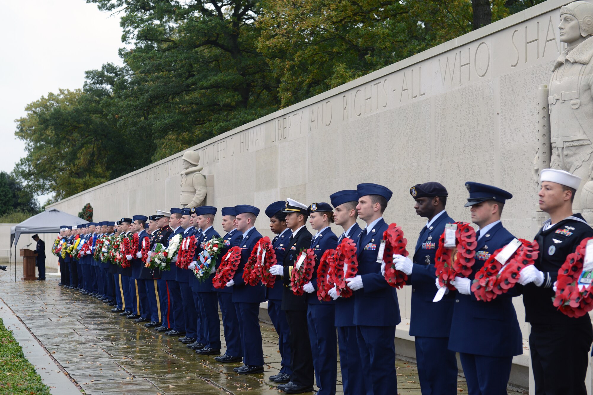 CAMBRIDGE, United Kingdom – Members of the 501st Combat Support Wing and its Mission Partners line up with wreaths at the base of the Tablets of the Missing in Cambridge American Cemetery, in Cambridge, United Kingdom, Nov. 11 during a Veterans Day ceremony. The ceremony honored the veterans of both the United States and United Kingdom. (U.S. Air Force photo by Tech. Sgt. Chrissy Best)