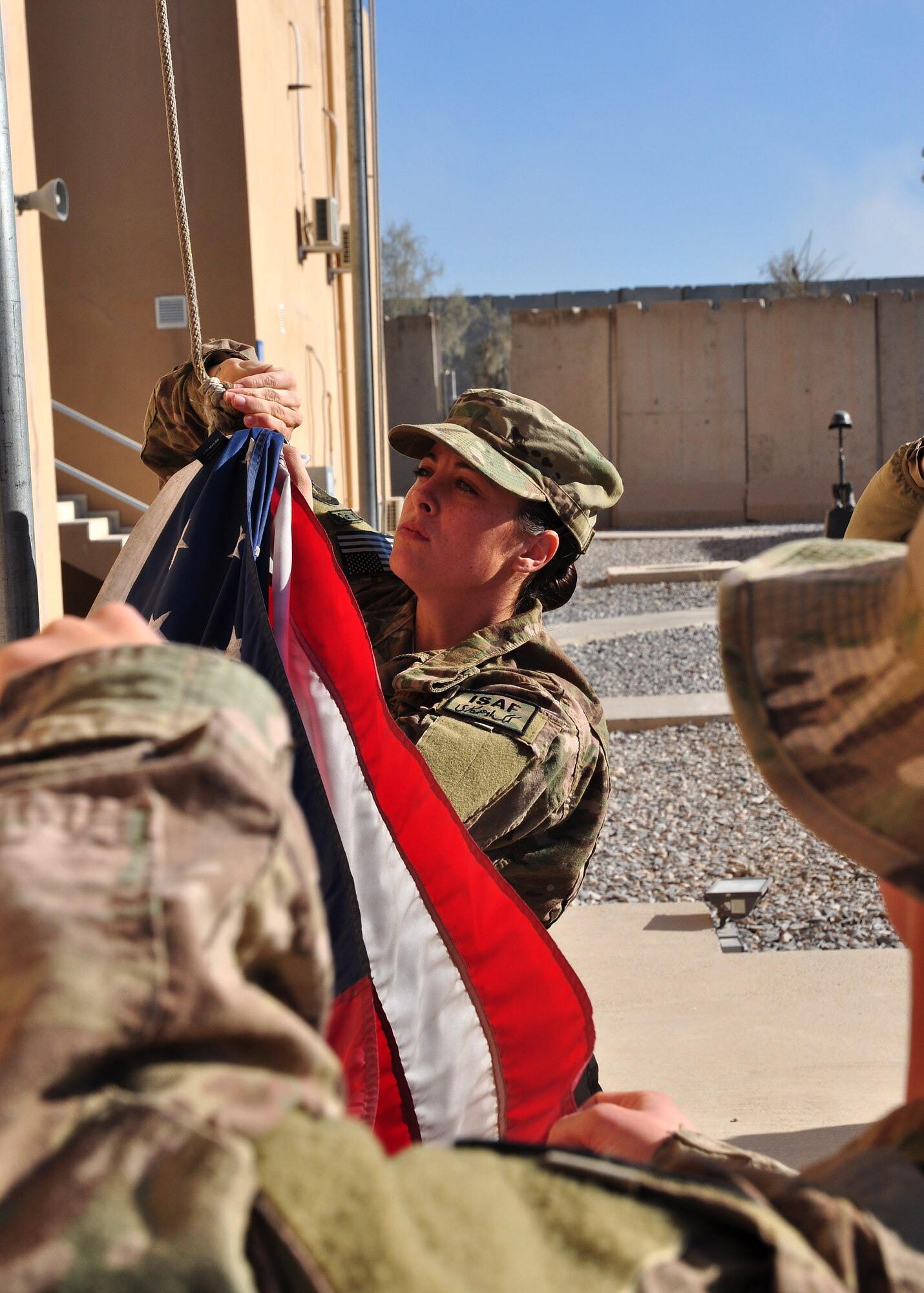 Airmen 1st Class Christina Armour, 451st Expeditionary Logistics Readiness Squadron, Kandahar Airfield, Afghanistan, prepares to raise the American flag at Camp Losano Nov. 11, 2013 – Veterans Day. A team of men and women from the 451st Air Expeditionary Wing flew 16 American flags over Camp Losano for individuals who wanted to commemorate the day with a flag. Each flag flown will be accompanied with a certificate. (U.S. Air Force photo by Capt. Jason Smith)
