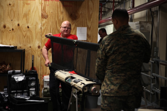 Michael A. Nace, an acute care nurse practitioner (left) with Lifeguard Medical Training, and a sailor with 2nd Medical Battalion, Combat Logistics Regiment 25, 2nd Marine Logistics Group test the weight and balance of a Portable Patient Transport Life Support System device when attached to a stretcher aboard Camp Lejeune, N.C., Nov. 5, 2013. PPTLSS can be carried by one person, weighs approximately 55 pounds and is scheduled to replace the multiple heavier life support systems currently used by the military. 