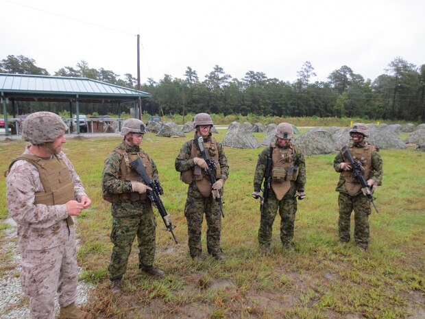 Lieutenant Cmdr. Eugene Wozniak speaks to Marine from 2nd Battalion, 9th Marine Regiment, 2nd Marine Division before the Marines begin a live-fire training exercise.