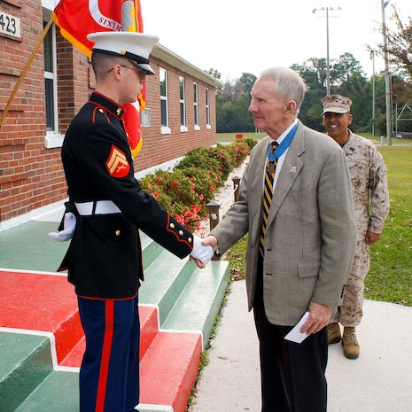 Major Gen. James E. Livingston (retired), greets a Marine in front of the 6th Marine Regiment headquarters building. Livingston, a Medal of Honor holder, is a former commander of the 6th Marine Regiment.