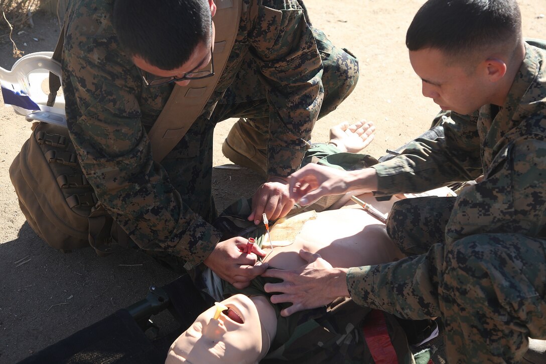 Seaman Daniel Benavidas, left, a logistics specialist, and Lance Cpl. Joshua Shed, right, a warehouse clerk, both with 1st Supply Battalion, Combat Logistics Regiment 15, 1st Marine Logistics Group, perform a lung inflation to a gunshot victim during a combat lifesavers course aboard Camp Pendleton, Calif., Nov. 6, 2013. During the course, Marines and sailors learned vital techniques such as providing CPR, treating injuries like sucking chest wounds and applying tourniquets. 