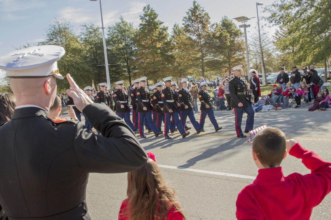 Virginia Beach, Va. (Nov. 11, 2013) –Col. Paul Ryan, commanding officer, Headquarters and Service Battalion, U.S. Marine Corps Forces Command, salutes the colors as they pass the reviewing stands during the Virginia Beach Veterans Day Parade Nov. 11. A parade has been held in Virginia Beach each year for more than 40 years. This year HQSVBN provided a color guard and parching platoon to represent the Marine Corps.