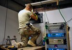 Airman 1st Class Kostikey Mustakas, 455th Expeditionary Communications Squadron engineering and installation journeyman, installs fiber into a termination panel in the weather office on Bagram Air Field, Afghanistan, Sept. 12, 2013. He is deployed from Stewart Air National Guard Base, N.Y.