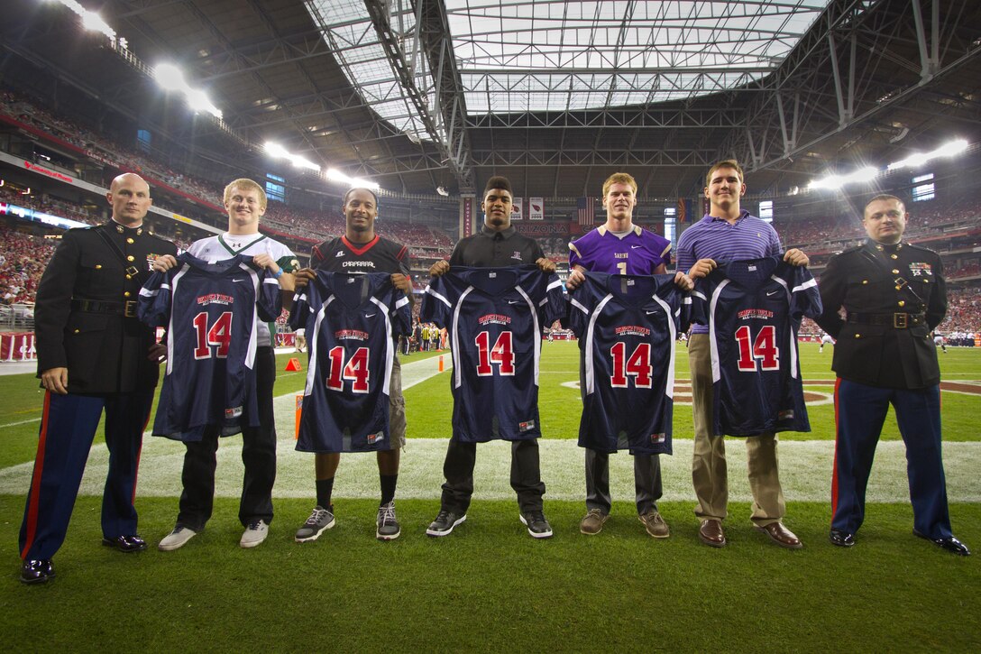 U.S. Marine Corps Captains Matthew Browning and Jeffrey Arroyo, of Marine Corps Recruiting Station Phoenix, present Semper Fidelis All-American jerseys to five student-athletes selected from the state of Arizona, during halftime of the sold out Houston Texans versus Arizona Cardinals football game at the University of Phoenix Stadium in Glendale, Ariz., Nov. 10, 2013. The players were carefully chosen based on their efforts in the classroom, community and on the gridiron.
