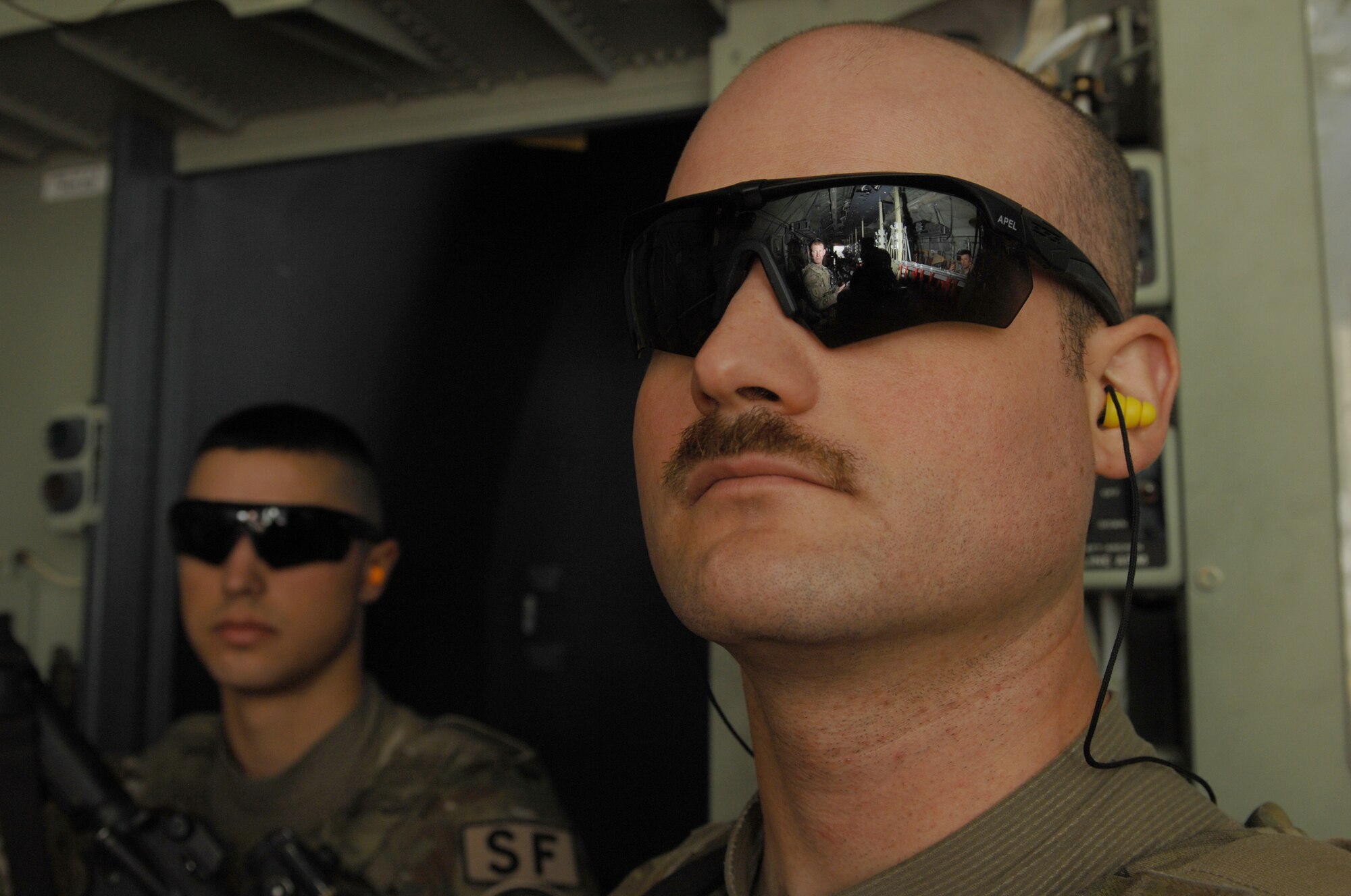 Senior Airman James Angiola (left), and Senior Airman Justin Kinkade (right), provide flight deck denial aboard a C-130J Hercules Oct. 26, 2013, over Southwest Asia. Both Airmen are assigned to the 451st Expeditionary Security Forces Squadron Fly Away Security Team. (U.S. Air Force photo by Senior Airman Jack Sanders)