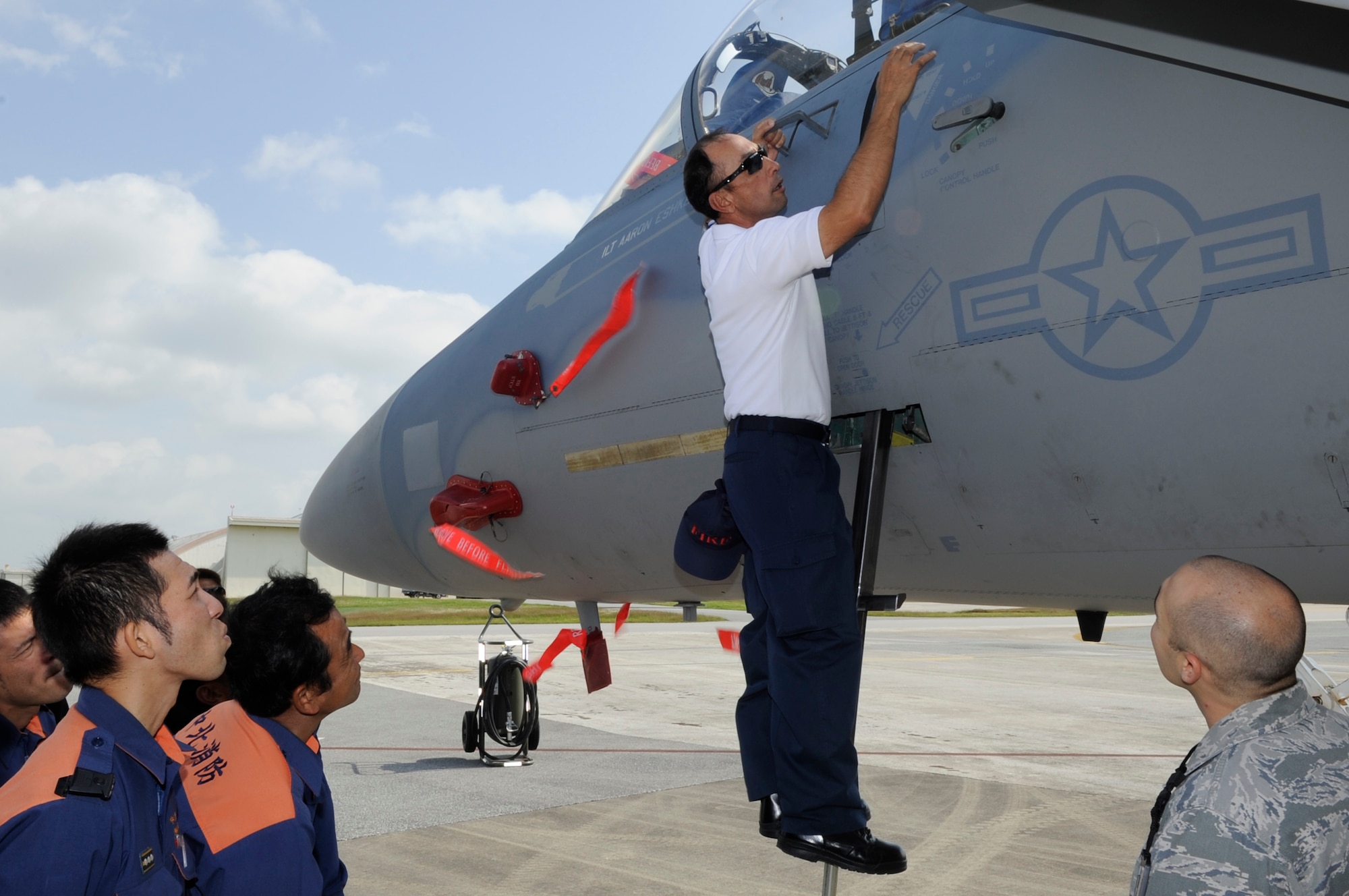 Kenichi Shimajiri, 18th Civil Engineer Squadron fire inspector, demonstrates to local emergency first responders how to open an F-15 Eagle’s canopy at Kadena Air Base, Japan, Nov. 6, 2013. The first responders are taught how to deal with the various aircraft assigned to military installations on Okinawa in the unlikely event an aircraft makes an emergency landing off base or crashes. (U.S. Air Force photo by Senior Airman Marcus Morris)