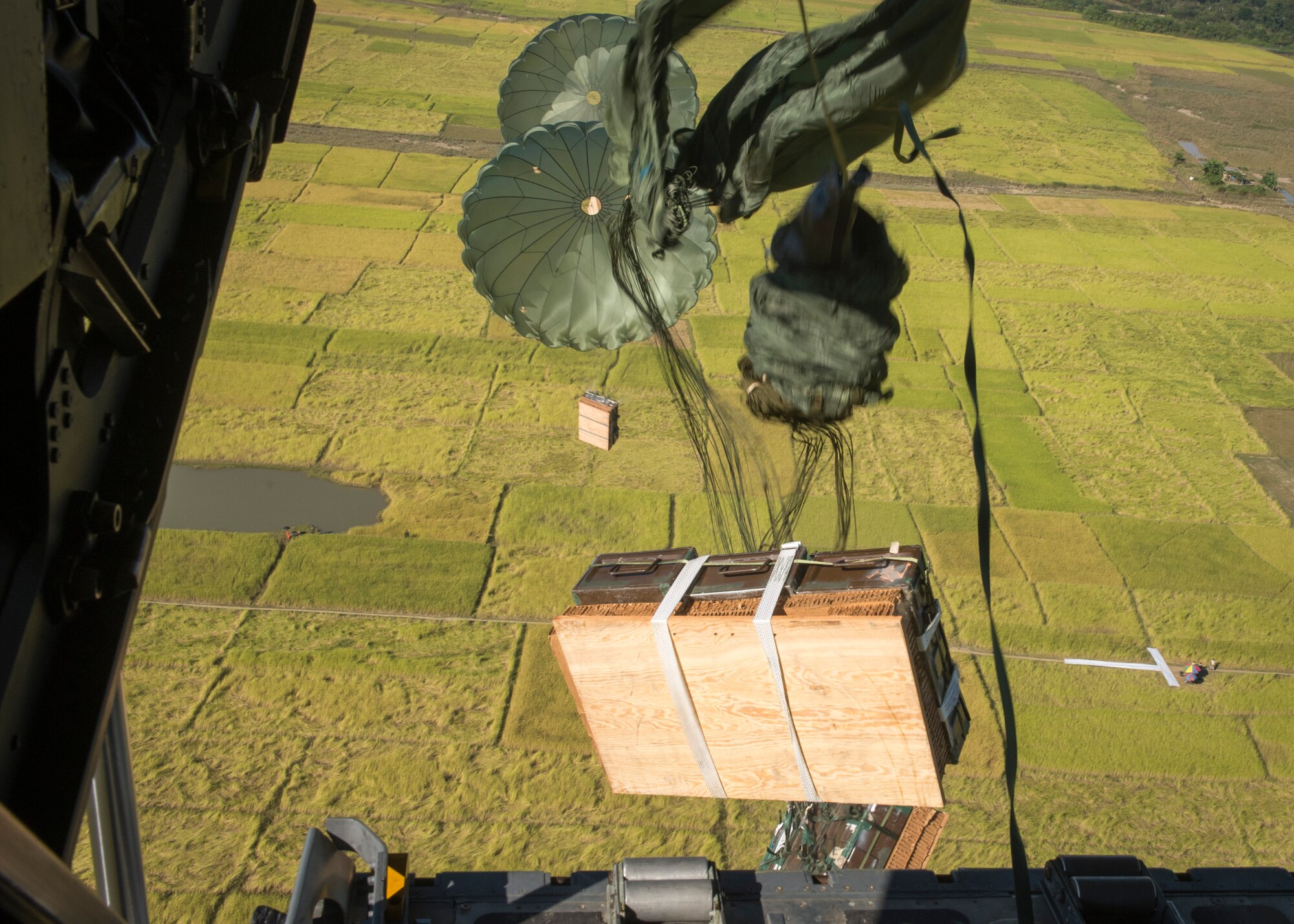 A U.S. C-130 Hercules drops four Low-Cost, Low Altitude airdrop bundles during exercise Cope South over Bangladesh, Nov. 12, 2013. The exercise focuses on conducting tactical airlift operations in order to better respond to regional disasters. (U.S. Air Force photo by Captain Raymond Geoffroy/Released)