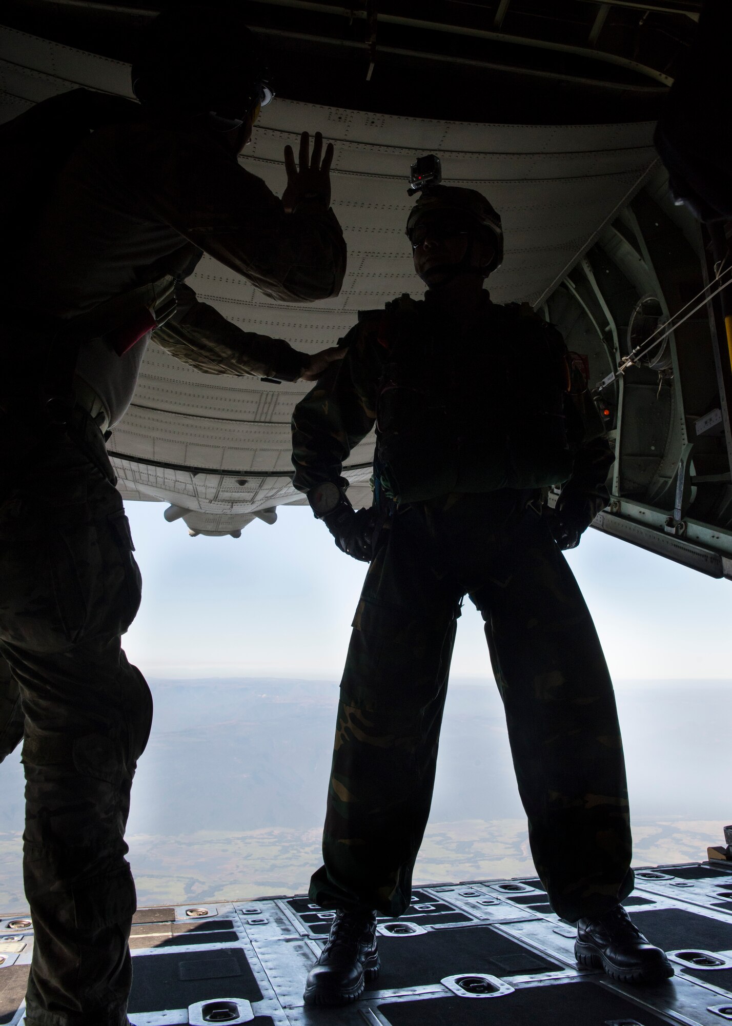 A U.S. Jumpmaster communicates with a Bangladeshi Commando aboard a U.S. C-130 Hercules during exercise Cope South over Bangladesh, Nov. 10, 2013. The exercise is designed to cultivate common bonds, foster goodwill, and improve readiness and compatibility between members of the Bangladesh and U.S. Air Force. (U.S. Air Force photo by Captain Raymond Geoffroy/Released)