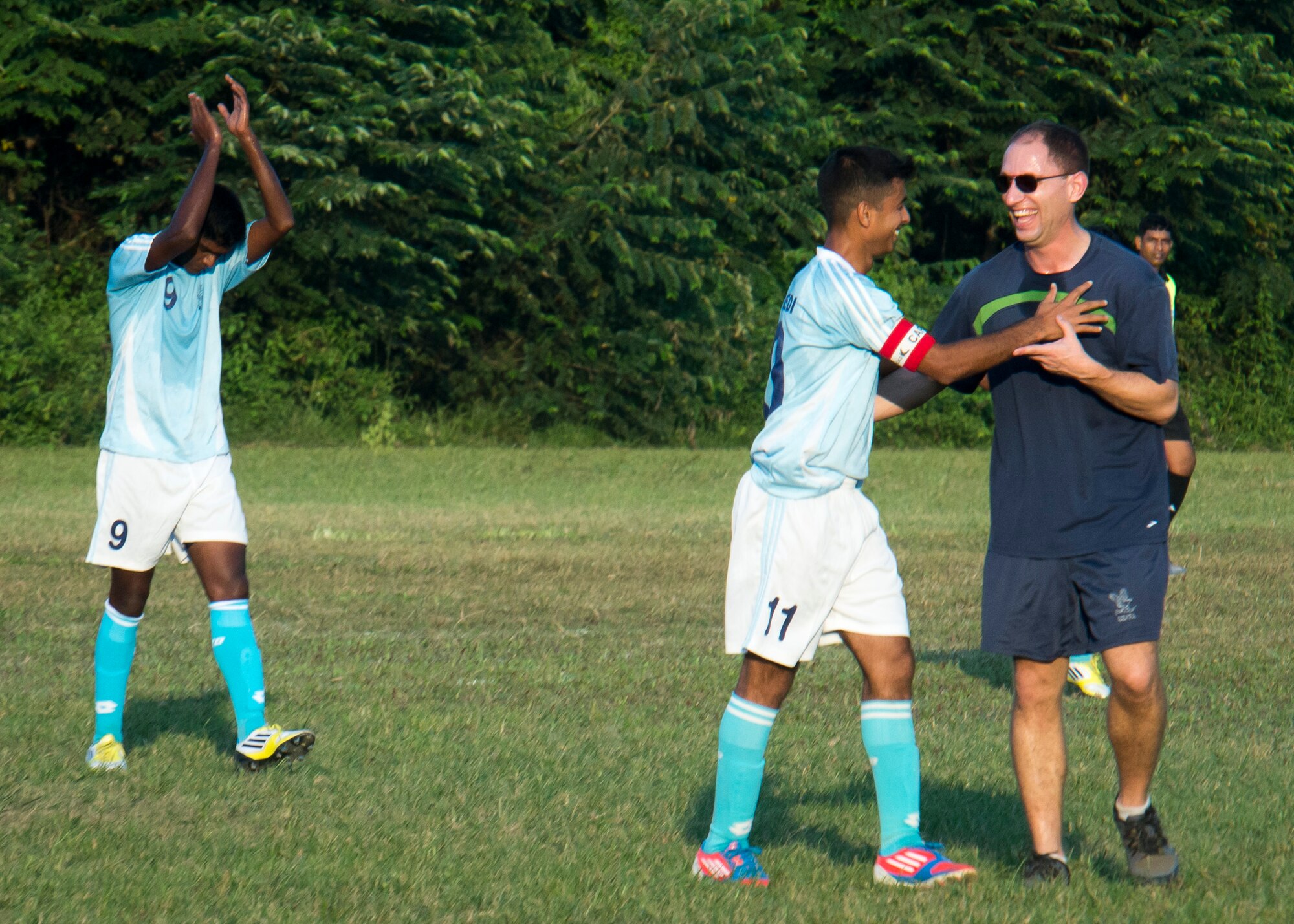 A member of the official Bangladesh Air Force soccer team encourages Captain Mark Nexton, a pilot from the 36th Airlift Squadron, during a match at Bangabandhu Air Base, Bangladesh, Nov. 8, 2013. Nexton joins approximately 80 U.S. Airmen participating in exercise Cope South in Bangladesh. (U.S. Air Force photo by Captain Raymond Geoffroy/Released)