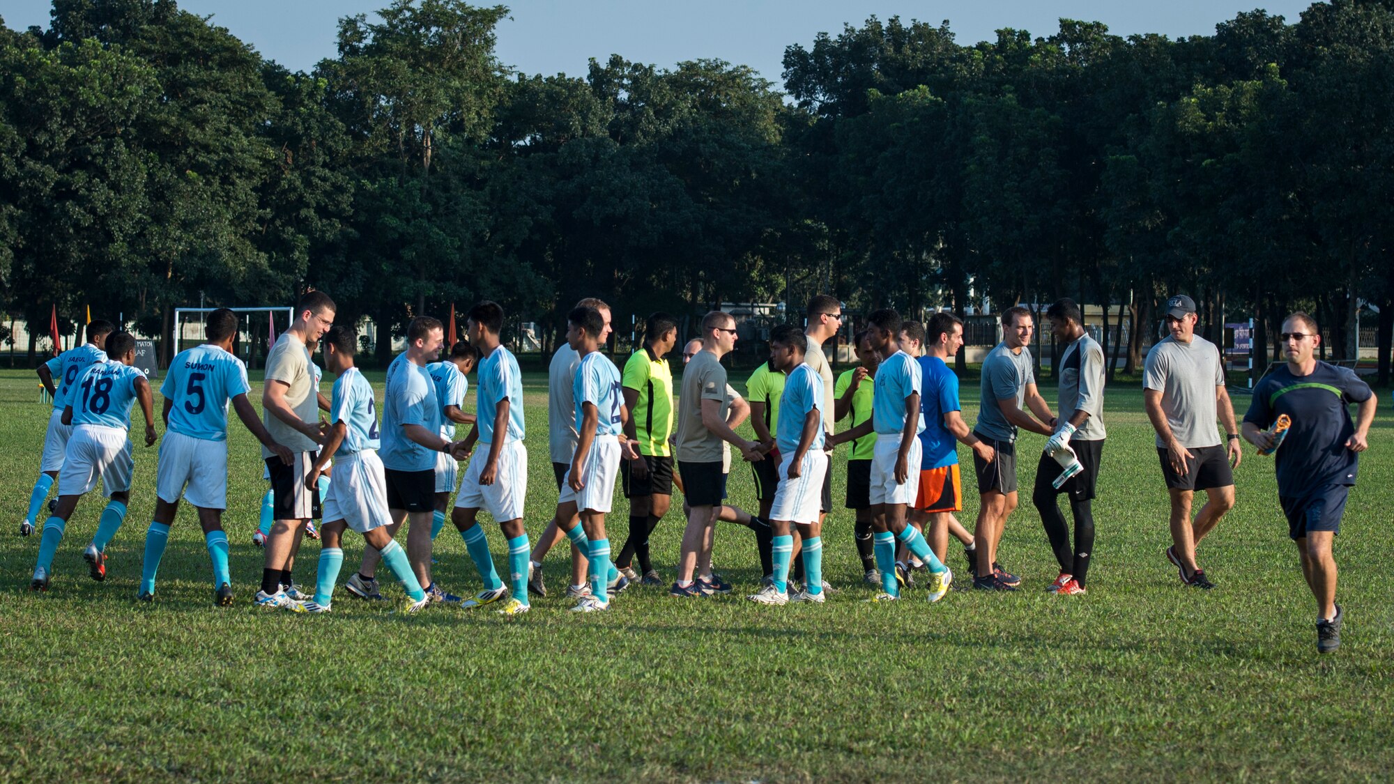 U.S. Airmen participating in exercise Cope South 14 shake hands with members of the official Bangladesh Air Force soccer team during a match at Bangabandhu Air Base, Bangladesh, Nov. 8, 2013. Cope South is a bilateral airlift exercise meant to cultivate common bonds, foster goodwill, and improve readiness and compatibility between members of the Bangladesh and U.S. Air Force. (U.S. Air Force photo by Captain Raymond Geoffroy/Released)