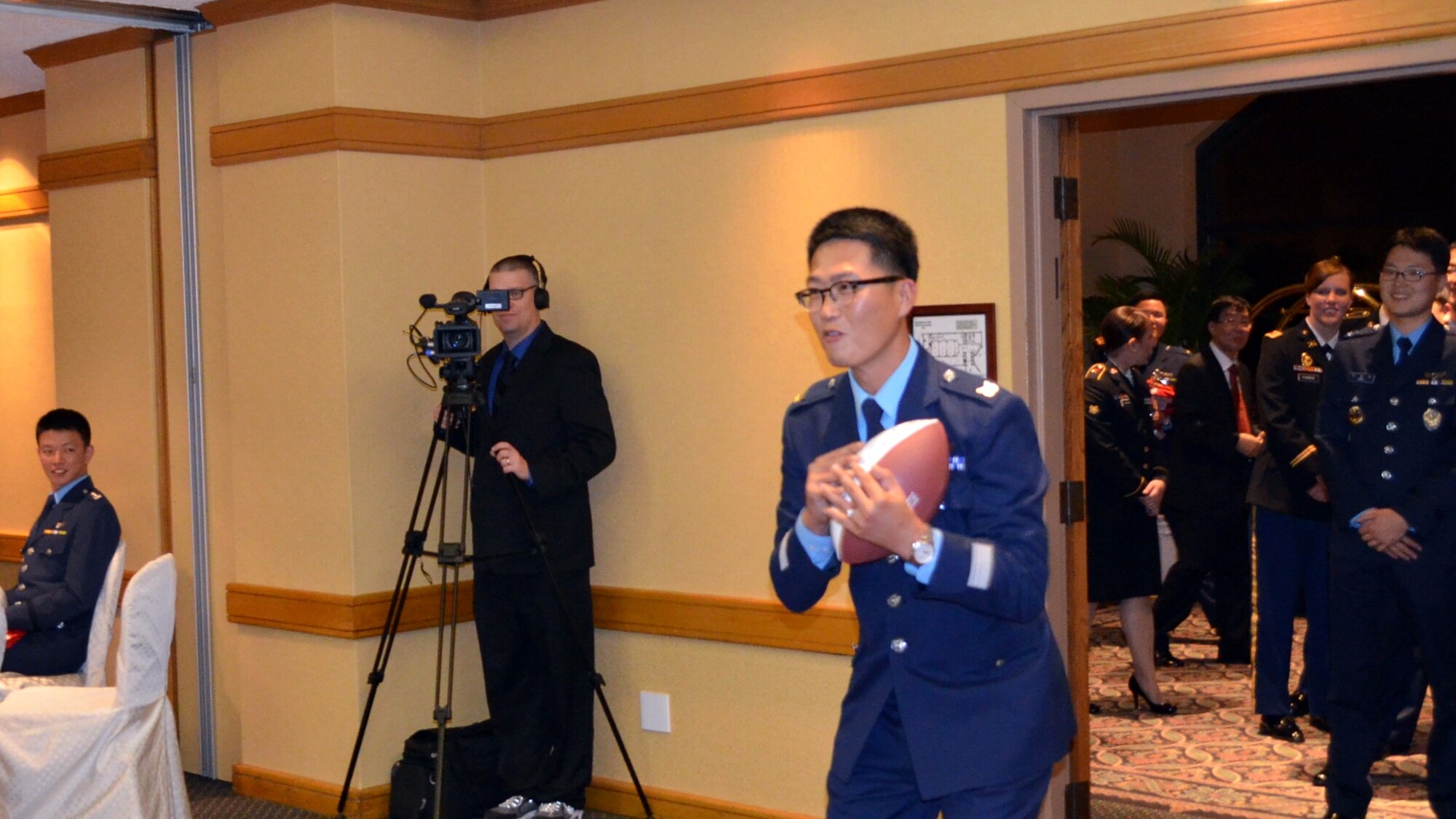 OSAN AB, Republic of Korea – A Republic of Korea Air Force winner of the Peninsula Missile Defender of the Year award catches a football thrown by Riki Ellison, chairman and founder of the non-profit Missile Defense Advocacy Alliance and three-time Superbowl champion with the San Francisco 49ers, at a banquet in Seoul, Nov. 8. (U.S. Army photo by Spc. Shawn Denham, 35th ADA Public Affairs)
