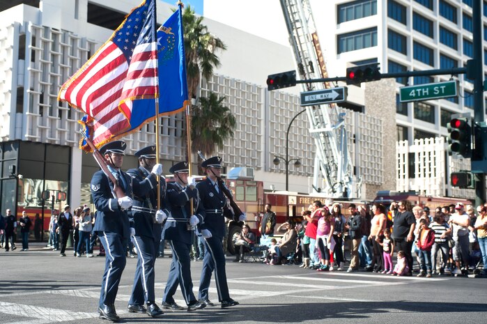 Nellis Air Force Base Honor Guard members, march down 4th Street during the Las Vegas Veterans Day Parade Nov. 11, 2013, in Las Vegas. Brig. Gen. Stephen Whiting, U.S. Air Force Warfare Center vice commander, provided opening remarks before the parade and redeploying Airmen participated in the parade. Whiting also sat at the review stand at the end of the parade and was able to view drill performances given by Junior ROTC cadets. (U.S. Air Force photo by Staff Sgt. Christopher Hubenthal)