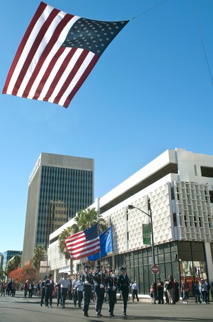 Nellis Air Force Base Honor Guard members march down 4th Street during the Las Vegas Veterans Day Parade Nov. 11, 2013, in Las Vegas. Brig. Gen. Stephen Whiting, U.S. Air Force Warfare Center vice commander, provided opening remarks before the parade began and redeploying Airmen participated in the parade. Whiting also sat at the review stand at the end of the parade and was able to view drill performances given by Junior ROTC cadets. (U.S. Air Force photo by Staff Sgt. Christopher Hubenthal)