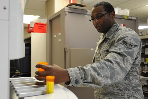 Airman Marcus Bullock, 92nd Medical Group pharmacy technician, operates the pharmASSIST robot X in the pharmacy at Fairchild Air Force Base, Wash., Nov. 12, 2013. The pharmASSIST robot is a machine that holds about 200 different prescriptions and, when programmed, will automatically fill and label them. (U.S. Air Force photo by Airman 1st Class Janelle Patiño/Released)