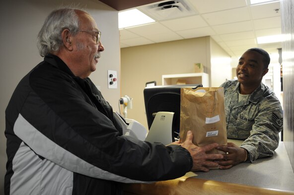 Staff Sgt. William Martin, 92nd Medical Group pharmacy technician, hands a bag of prescribed medications to a patient at Fairchild Air Force Base, Wash., Nov. 12, 2013.The main pharmacy is open on Mondays from 8 a.m. to 4:30 p.m. and Tuesday to Friday from 7:30 a.m. to 4:30 p.m. (U.S. Air Force photo by Airman 1st Class Janelle Patiño/Released)