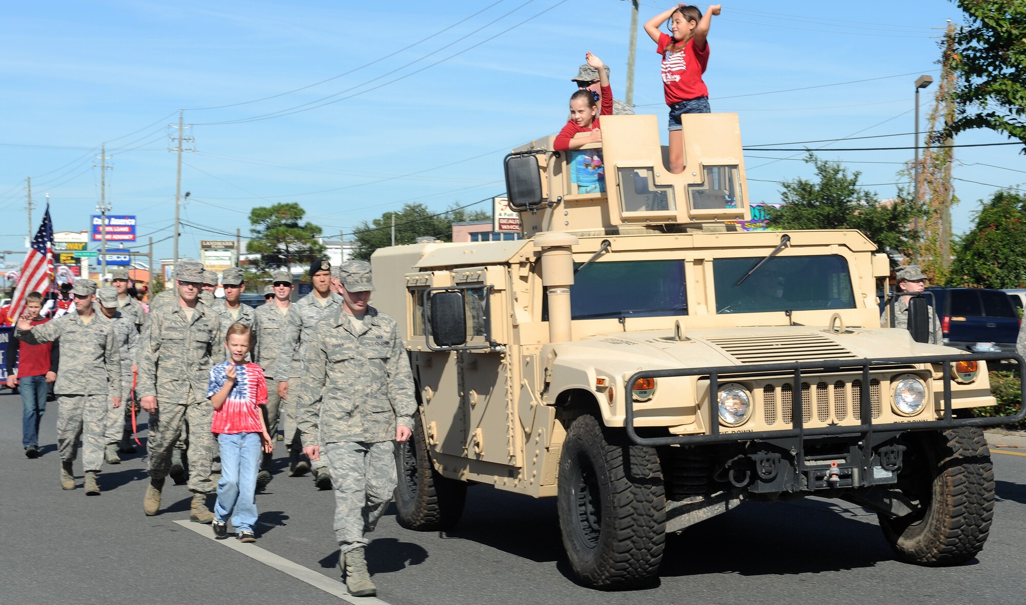 Hurlburt Field Air Commandos march alongside a Humvee during the Veteran’s Day parade in Mary Esther, Fla., Nov. 11, 2013. The Humvee, displayed throughout the parade, is a iconic vehicle in various U.S. military operations. (U.S. Air Force photo/Senior Airman Kentavist P. Brackin)