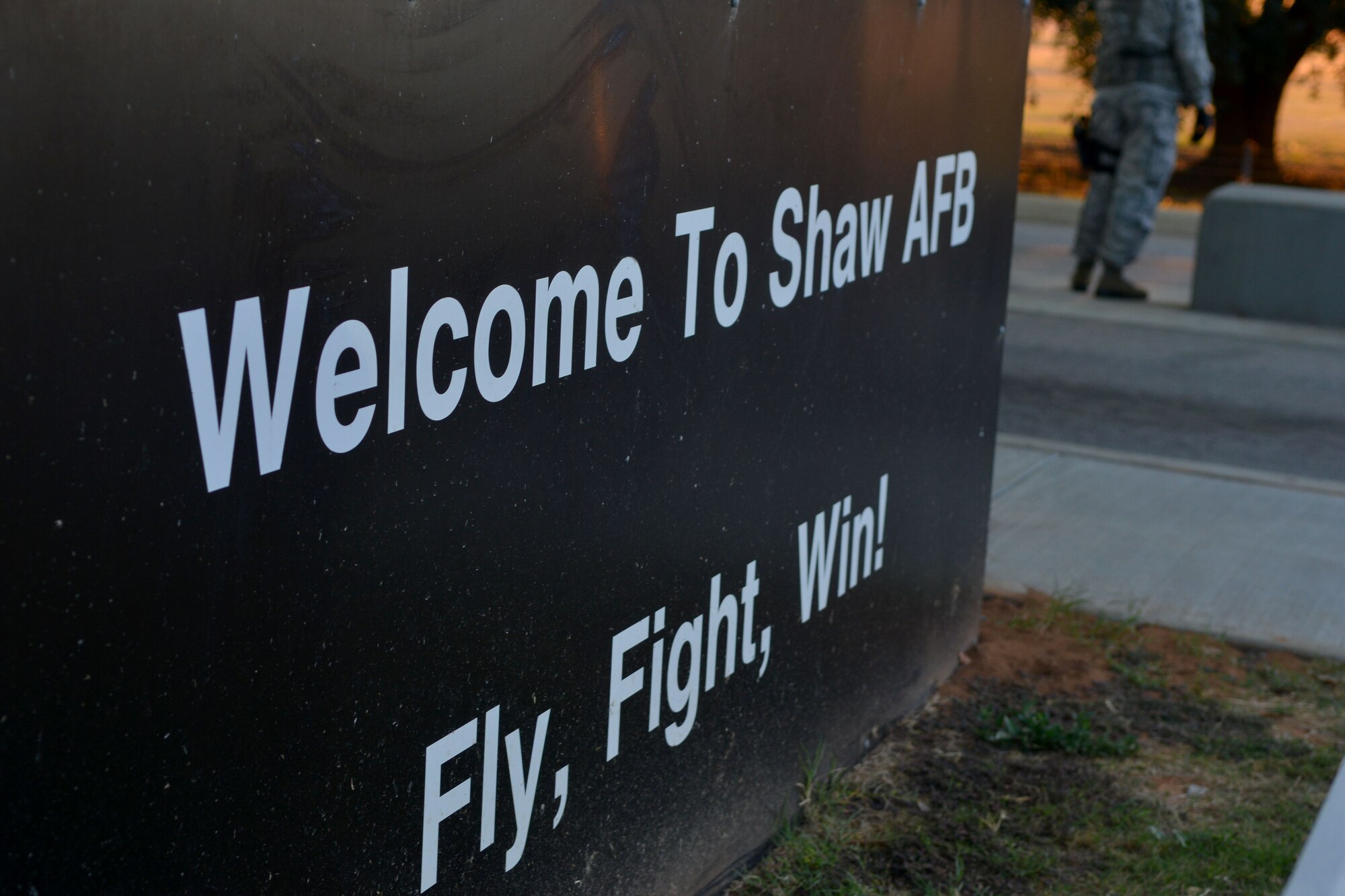 Oncoming traffic is greeted by a welcoming sign along with a security forces member, Shaw Air Force Base, S.C., Nov. 12, 2013. Airmen from the 20th Security Forces Squadron work long hours to ensure the safety of Team Shaw personnel and the 20th Fighter Wing assets. (U.S. Air Force photo by Airman 1st Class Ashley L. Gardner/Released)