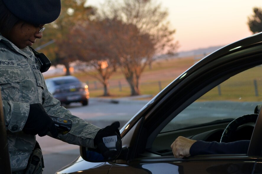 U.S. Air Force Senior Airman Shantel Hendricks, 20th Security Force Squadron patrolman, scans an identification card of incoming personnel, Shaw Air Force Base, S.C., Nov. 12, 2013. Before entering the base, drivers must present an acceptable identification card to entry controllers. (U.S. Air Force photo by Airman 1st Class Ashley L. Gardner/Released)
