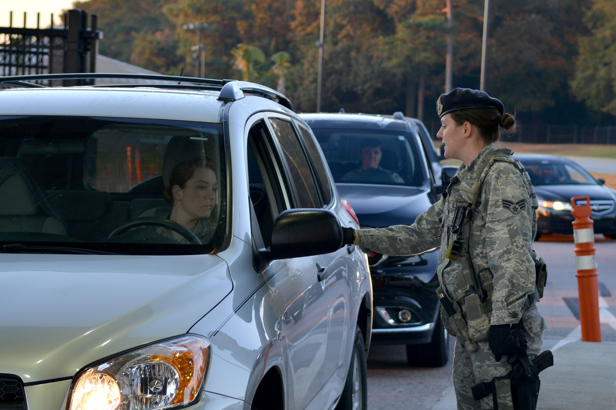 U.S. Air Force Senior Airman Angela Peaden, 20th Security Force Squadron patrolman, checks an oncoming military member’s credentials before allowing them to enter Shaw Air Force Base, S.C., Nov. 12, 2013. The 20th SFS is tasked with the mission to secure and defend Shaw and they are expected to protect the base and its assets 24/7. (U.S. Air Force photo by Airman 1st Class Ashley L. Gardner/Released)

