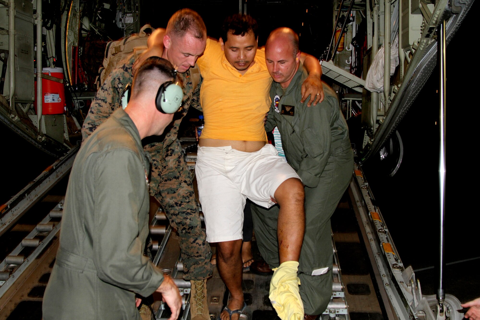 U.S. Marines carry an injured Filipino man off the back of a KC-130J Super Hercules at Villamor Air Base, Manila, the Philippines, Nov. 11, 2013. Defense Secretary Chuck Hagel directed the U.S. Marines to provide humanitarian relief at the request of the government of the Phillippines. (U.S. Marine Corps photo/Lance Cpl. Stephen D. Himes)