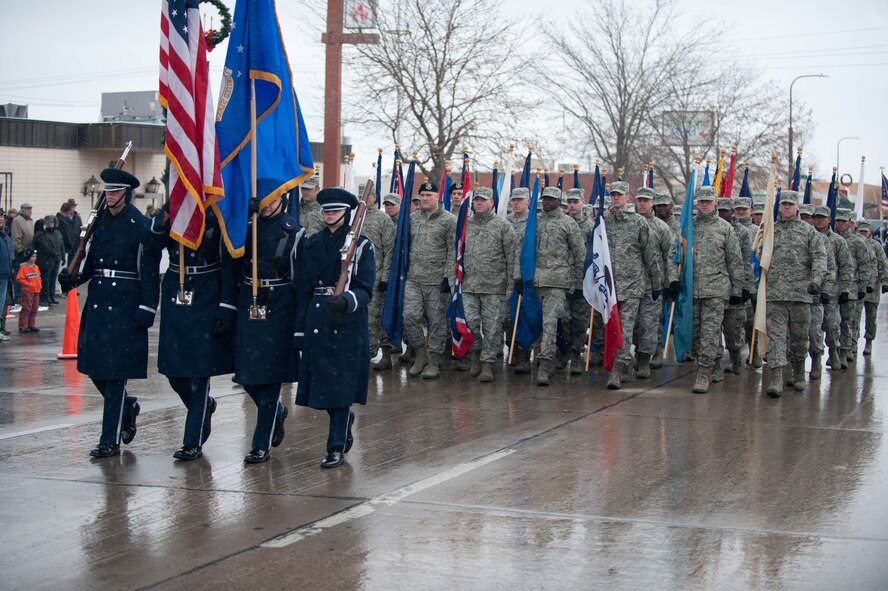 Members of the Ellsworth Honor Guard lead a flight of 50 Airmen carrying the flags of each state during the Veterans Day parade in Rapid City, S.D., Nov. 11, 2013. During the parade, military members, their families and area residents joined base and local leaders to pay homage to all veterans – past and present. (U.S. Air Force photo by Senior Airman Zachary Hada/Released)