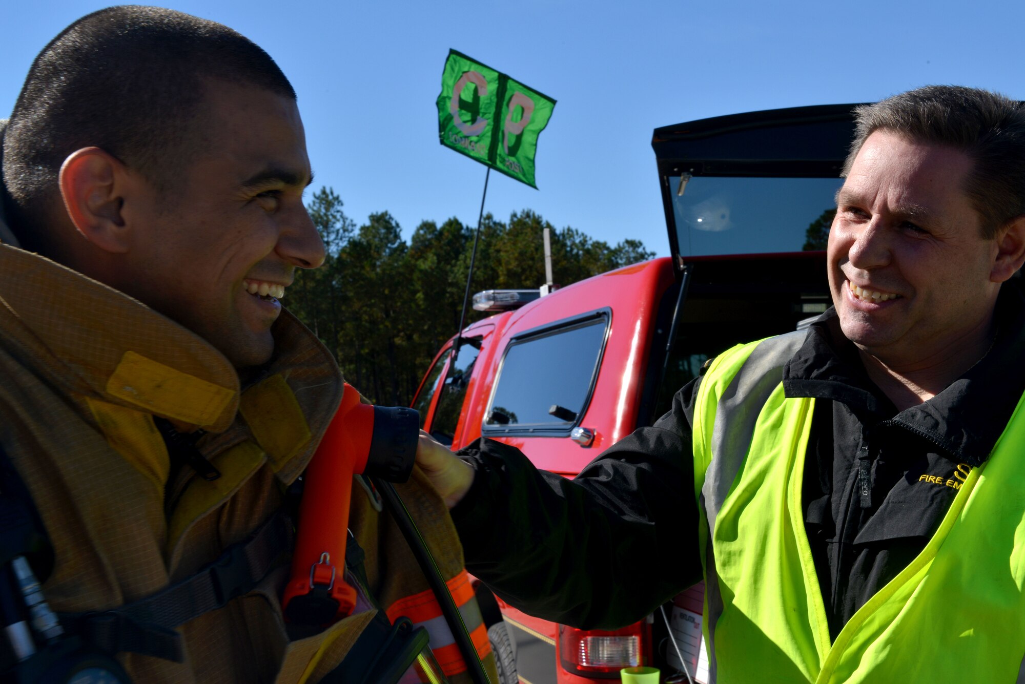 Firefighters from 20th Civil Engineering Squadron fire department discuss the major accident response exercise by the east gate, Shaw Air Force Base S.C., Nov. 8, 2013. During the exercise the fire department, security forces, medical group, explosive ordinance disposal, and supporting agencies across the wing responded to a simulated suspicious vehicle and a public health emergency. (U.S. Air Force photo by Airman 1st Class Jensen Stidham)