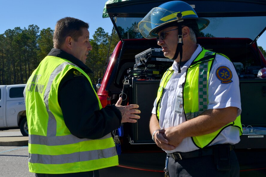 Firefighters from the 20th Civil Engineering Squadron fire department discuss a major accident response exercise by the east gate, Shaw Air Force Base S.C., Nov. 8, 2013. The fire department and other on base emergency personnel responded to a simulated suspicious vehicle and a public health emergency during the exercise. (U.S. Air Force photo by Airman 1st Class Jensen Stidham)
