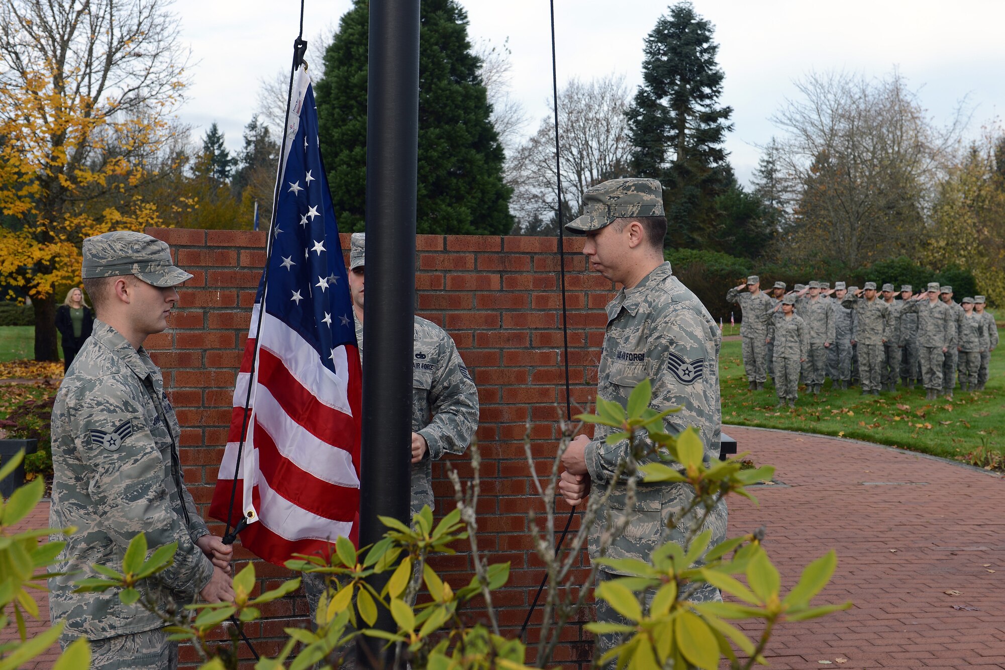 Senior Airman Ryan Johnson (left), 62nd Operation Support Squadron air traffic controller, and Staff Sgt. Robert Mangrum, 62nd Maintenance Squadron avionics technician, raise the U.S. flag Nov. 11, 2013 during a flag exchange ceremony at Joint Base Lewis-McChord, Wash. During the ceremony, Airmen replaced and retired the U.S., Prisoner Of War, and Washington state flags in honor of Veterans Day. (U.S. Air Force Photo/Airman 1st Class Jacob Jimenez)     