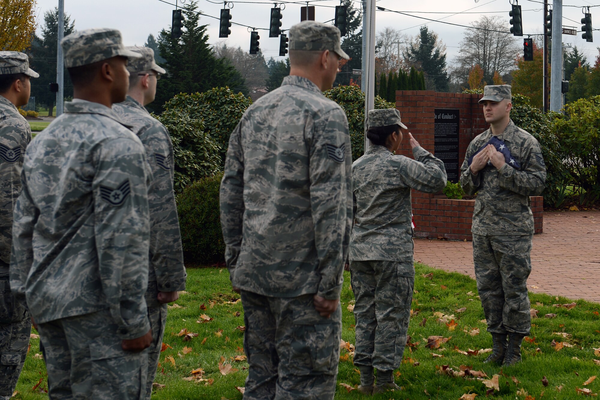 2nd Lt. Mayra Gomez, 62nd Airlift Wing Comptroller Squadron financial services flight commander, renders a salute as Staff Sgt. Jacob Womack, 62nd Aircraft Maintenance Squadron aircraft propulsions technician, presents the U.S. flag, Nov. 11, 2013 during a flag exchange ceremony at Joint Base Lewis-McChord, Wash. More than 30 Airmen volunteered to stand in formation to show their honor during the flag exchange ceremony. (U.S. Air Force Photo/Airman 1st Class Jacob Jimenez) 