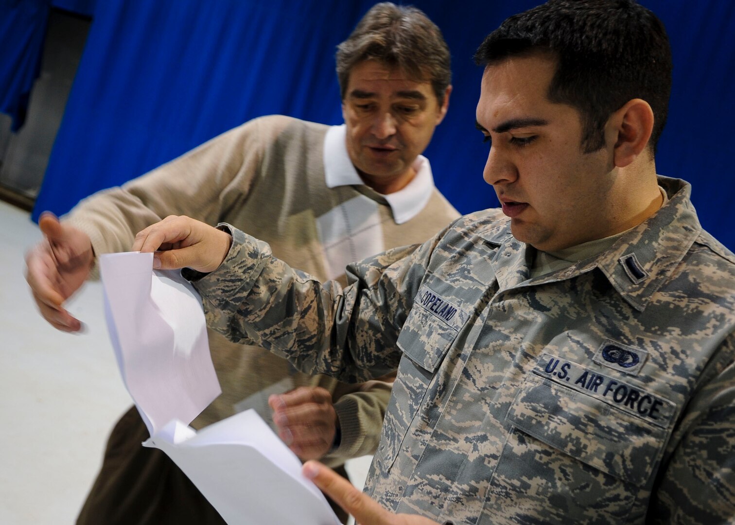 From right, U.S. Air Force 1st Lt. Chris Copeland, 633rd Air Base Wing protocol deputy chief, and Ricky Gibson, 633rd ABW protocol specialist, make last-minute changes to the seating arrangement at an assumption of command ceremony at Langley Air Force Base, Va., Nov. 4, 2013. The 633rd ABW protocol office manages both Fort Eustis and Langley protocol missions under the 633rd ABW. (U.S. Air Force photo by Airman 1st Class Austin Harvill/Released)