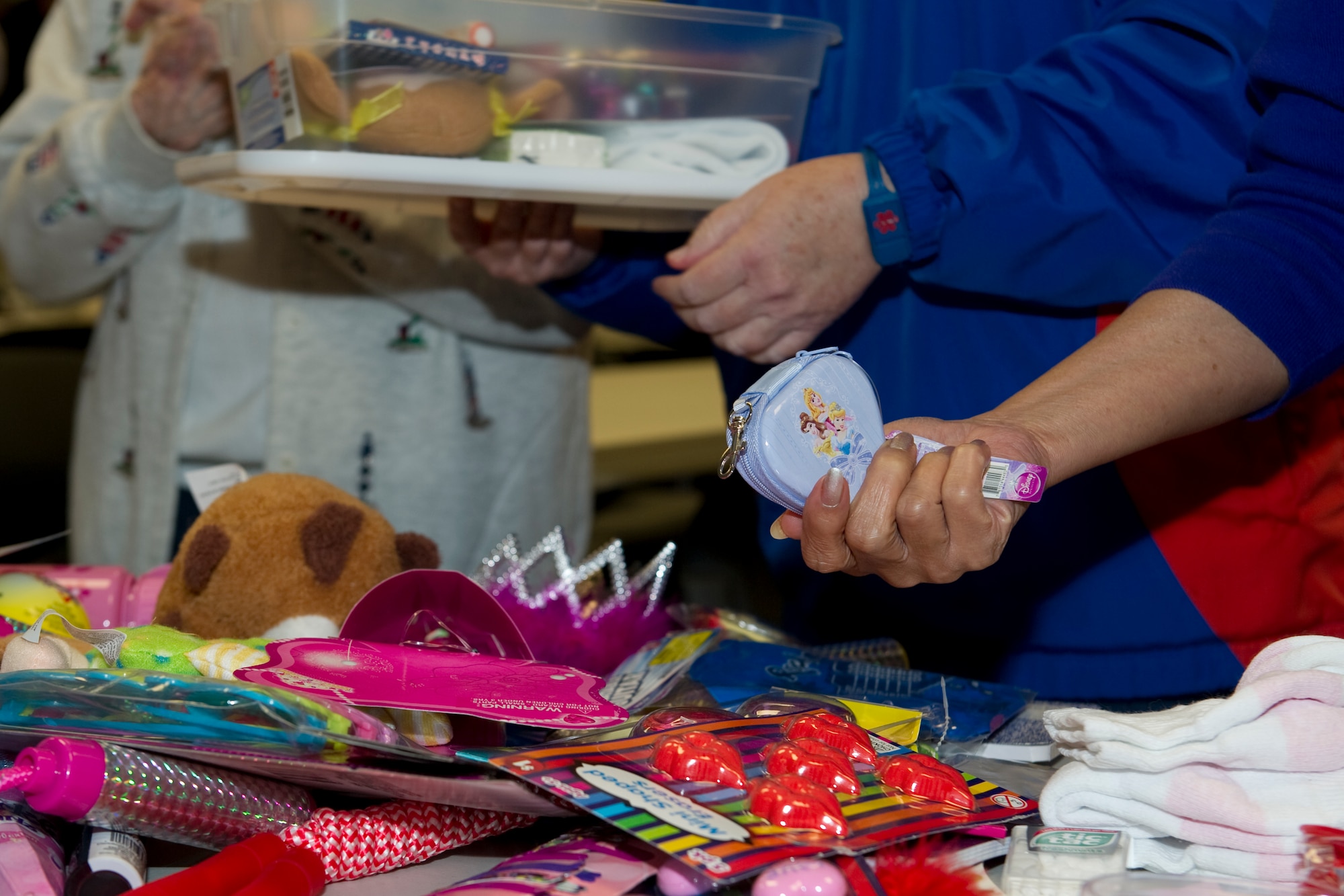 A chapel patron holds a children’s coin purse while packing a container in support of “Operation Christmas Child” at Hurlburt Field, Fla., Nov. 8, 2013. National Collection Week for Operation Christmas Child is Nov. 18 through 25. The chapel’s goal is to collect more than 150 boxes this year.  (U.S Air Force photo/Senior Airman Naomi Griego)