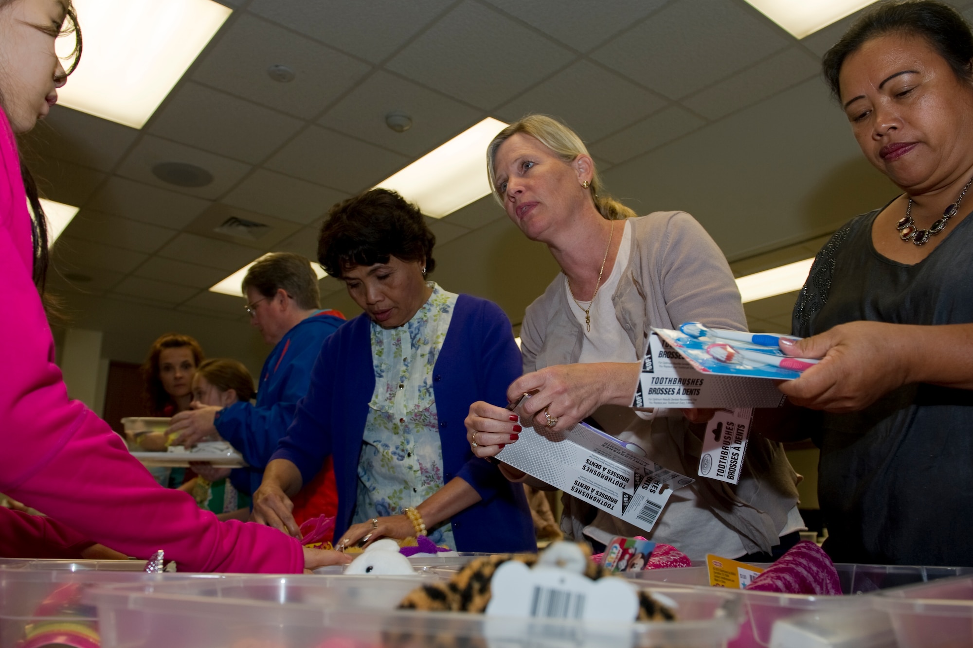 Chapel patrons sort through items and fill containers in support of “Operation Christmas Child” at Hurlburt Field, Fla., Nov. 8, 2013. Shoeboxes and a list of acceptable items are available at the chapel.  National Collection Week for Operation Christmas Child is Nov. 18 through 25. (U.S Air Force photo/Senior Airman Naomi Griego)