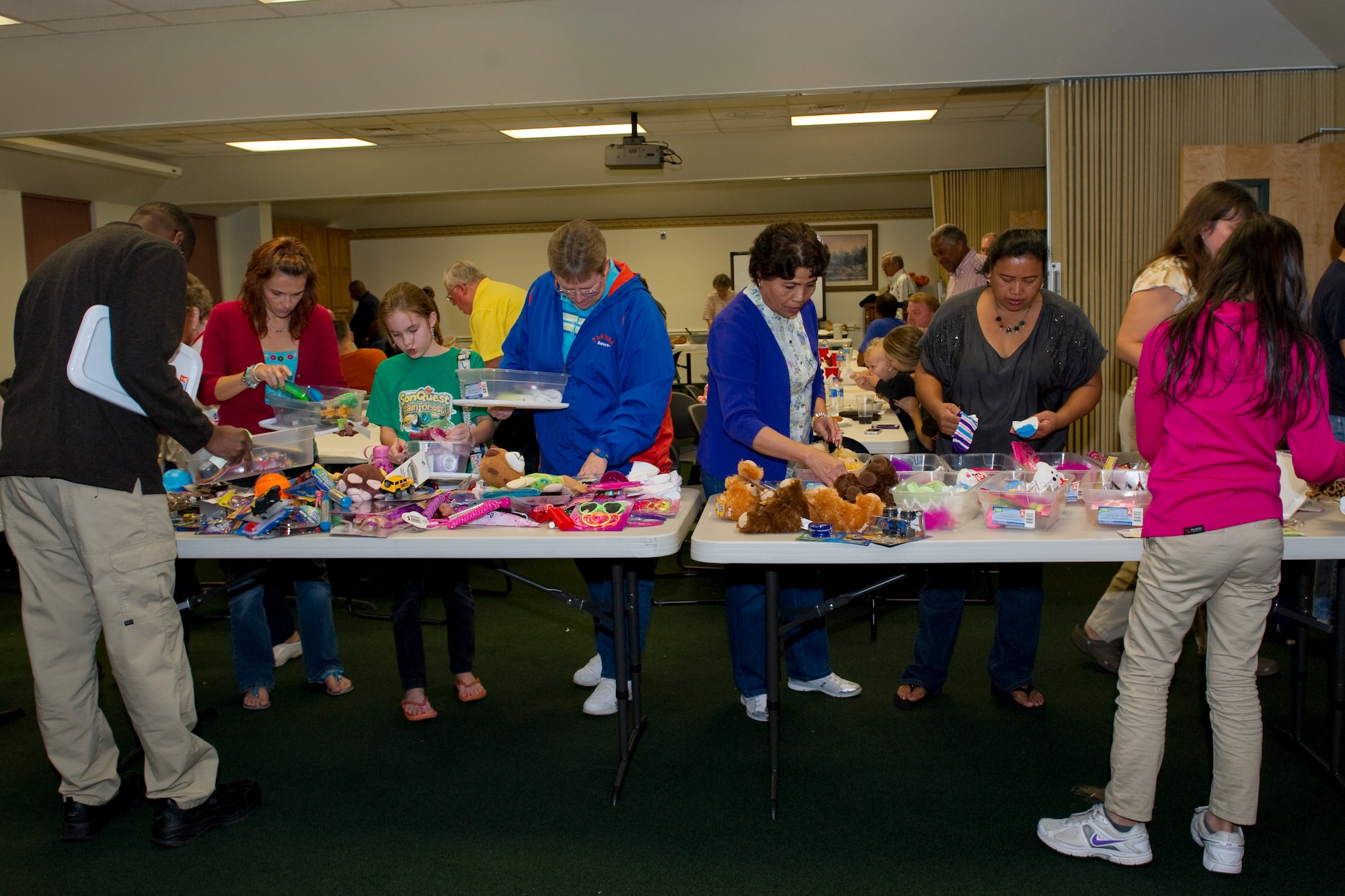 Volunteers fill plastic containers with gifts for “Operation Christmas Child” at the chapel on Hurlburt Field, Fla., Nov. 8, 2013. Since 1993 more than 100 million shoebox gifts were collected and distributed to needy children around the world in more than 130 countries. National Collection Week for Operation Christmas Child is Nov. 18 through 25. (U.S Air Force photo/Senior Airman Naomi Griego)
