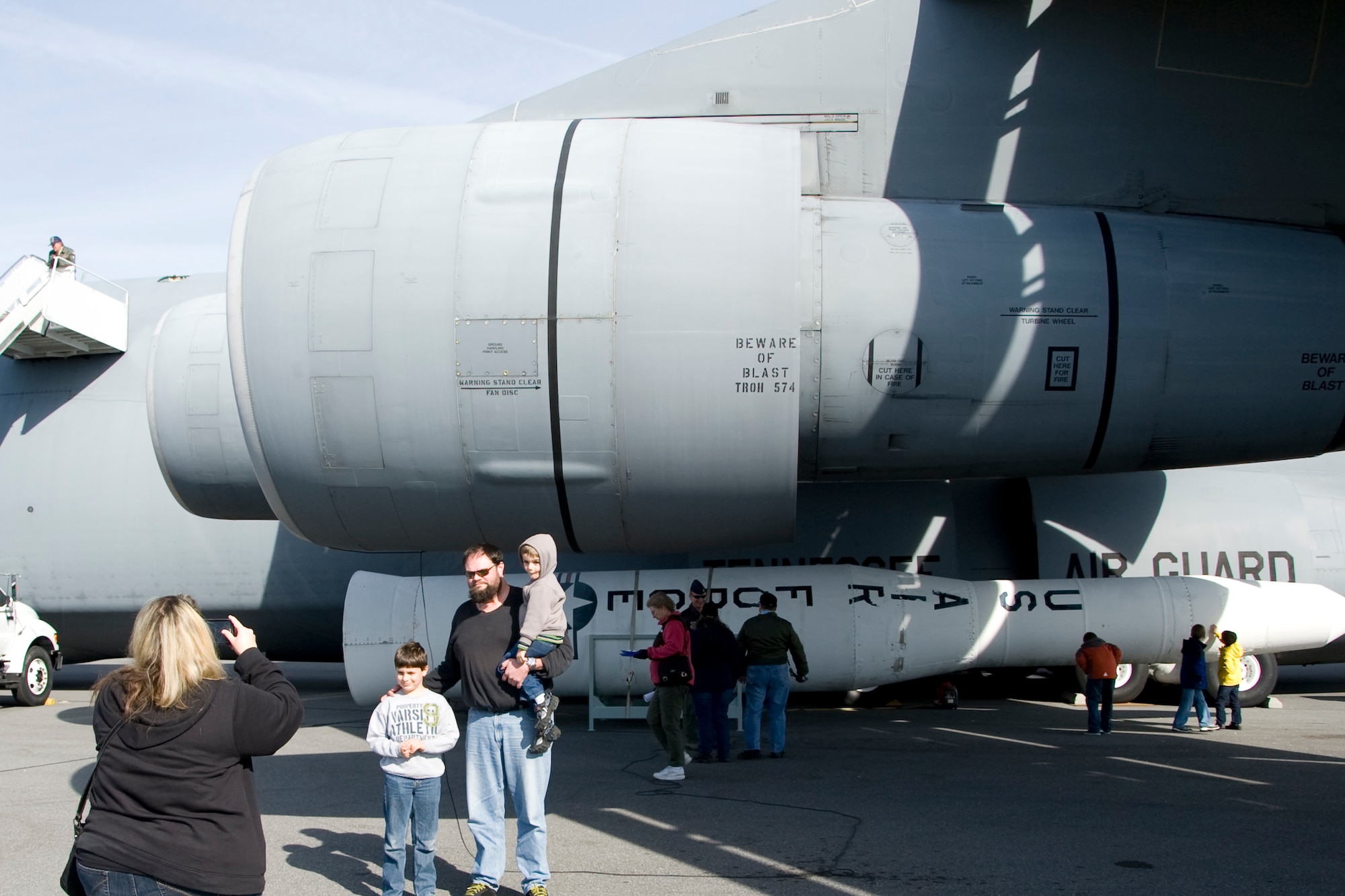 Ethan Labossiere and his two kids pose for Megan Collins in front of the newest edition to the Air Mobility Command museum’s aircraft lot, a C-5A Galaxy Nov. 9, 2013, at the AMC museum on Dover Air Force Base, Del. Labossiere and Collins are from the Philadelphia area and visit the museum often. (U.S. Air Force photo/Senior Airman Jared Duhon)