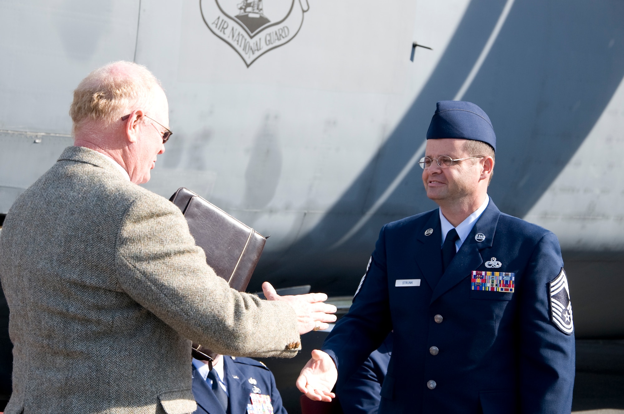 Chief Master Sgt. Sanford Strunk, 164th Airlift Wing, Tennessee Air National Guard aircraft maintenance superintendent, shakes hands with Michael Leister, Air Mobility Commander museum director, after handing him official documentation for the museum’s newest C-5A Galaxy Nov. 9, 2013, at the Dover Air Force Base, Del. The C-5A Galaxy will be the only C-5 on display in a museum for the next 10 years. (U.S. Air Force photo/Senior Airman Jared Duhon) 

